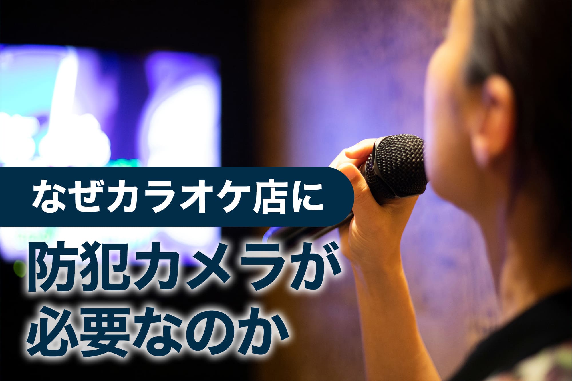 カラオケ店でマイクを持って歌う女性の後ろ姿とモニター画面