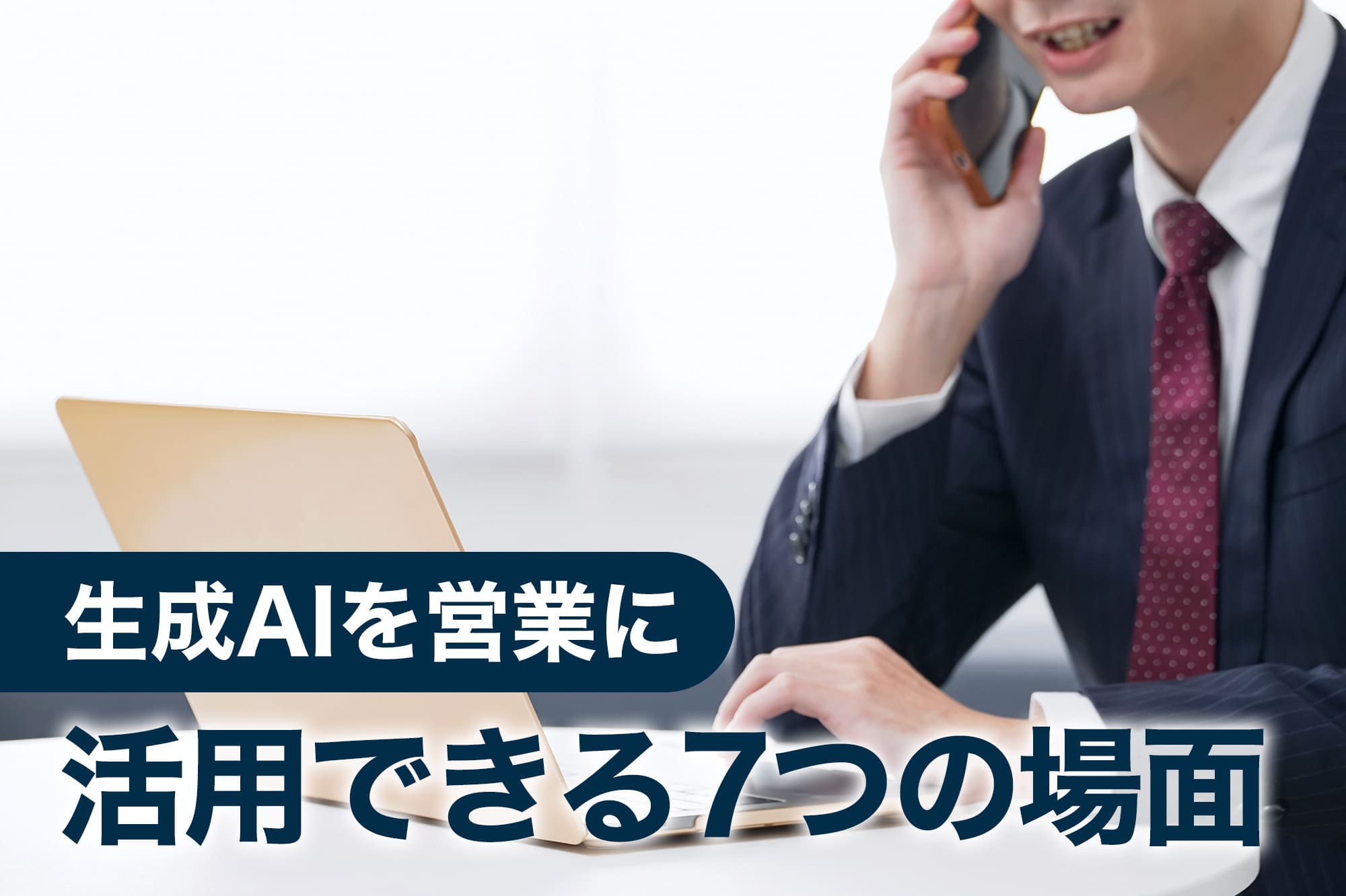 スマートフォンで通話しながらパソコン作業する営業担当者