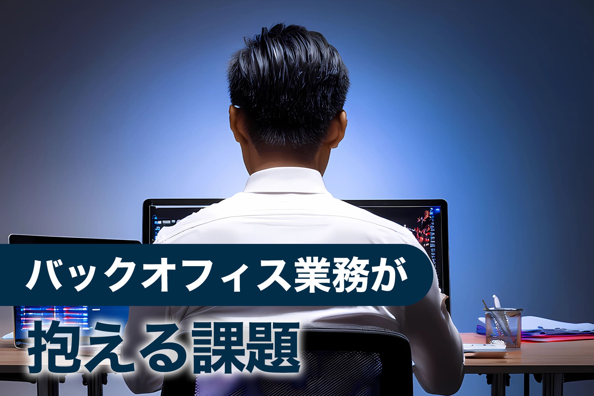 デスクトップパソコンで作業する男性の後ろ姿