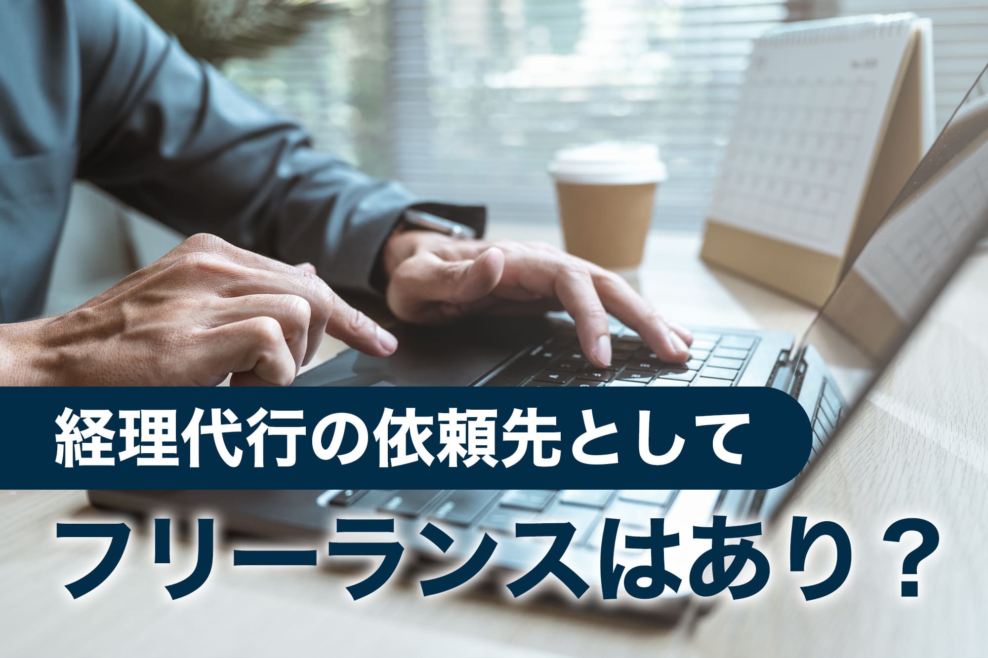 ノートパソコンを操作するスーツ姿の男性の手元