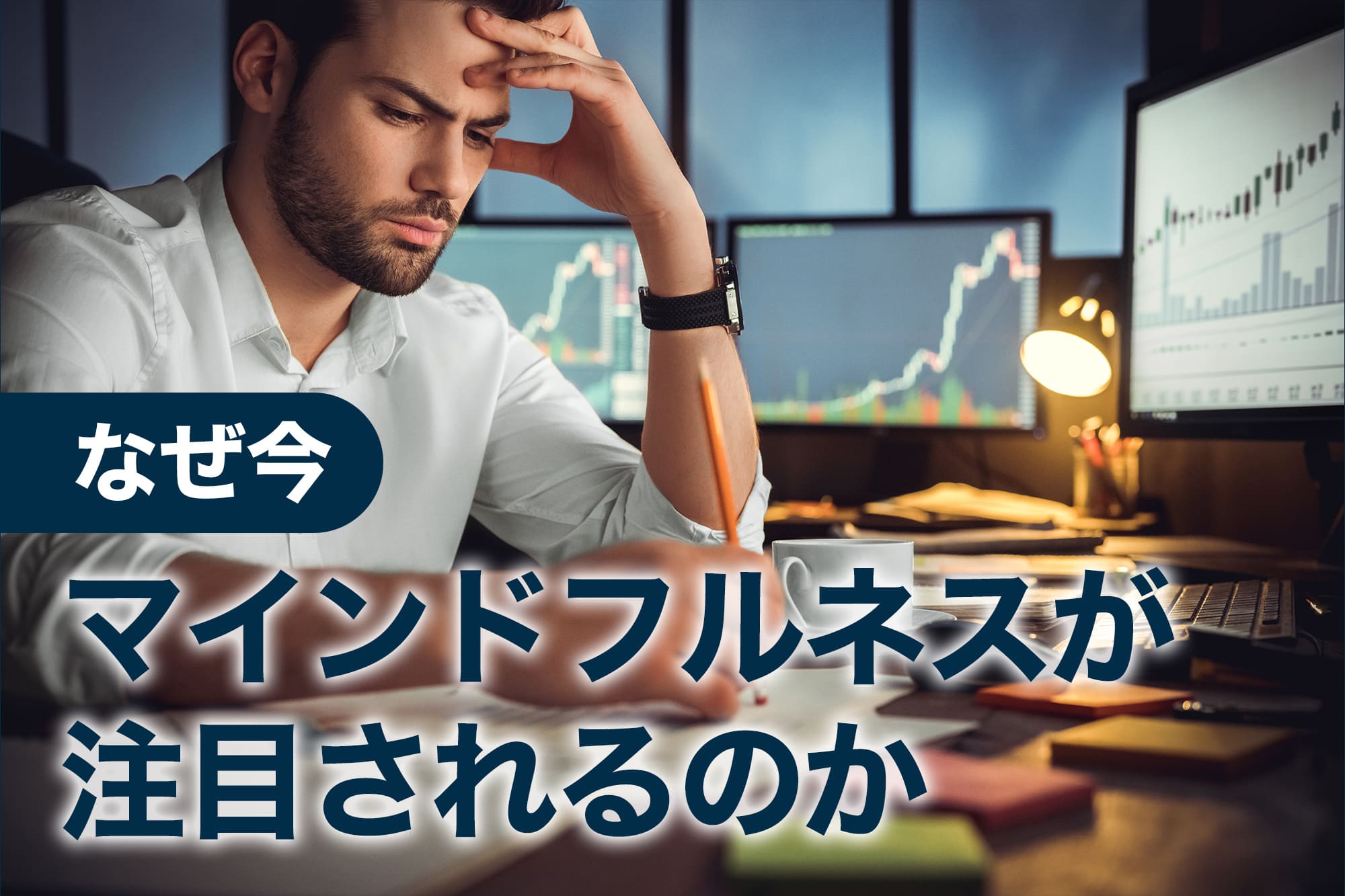 書類とグラフを前に悩む男性のデスクワーク風景